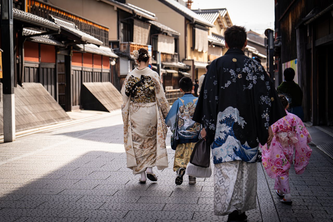 A Japanese family in colorful kimonos walking through a historic street in Kyoto, Japan.